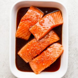 Baking dish with raw salmon and salmon marinade.