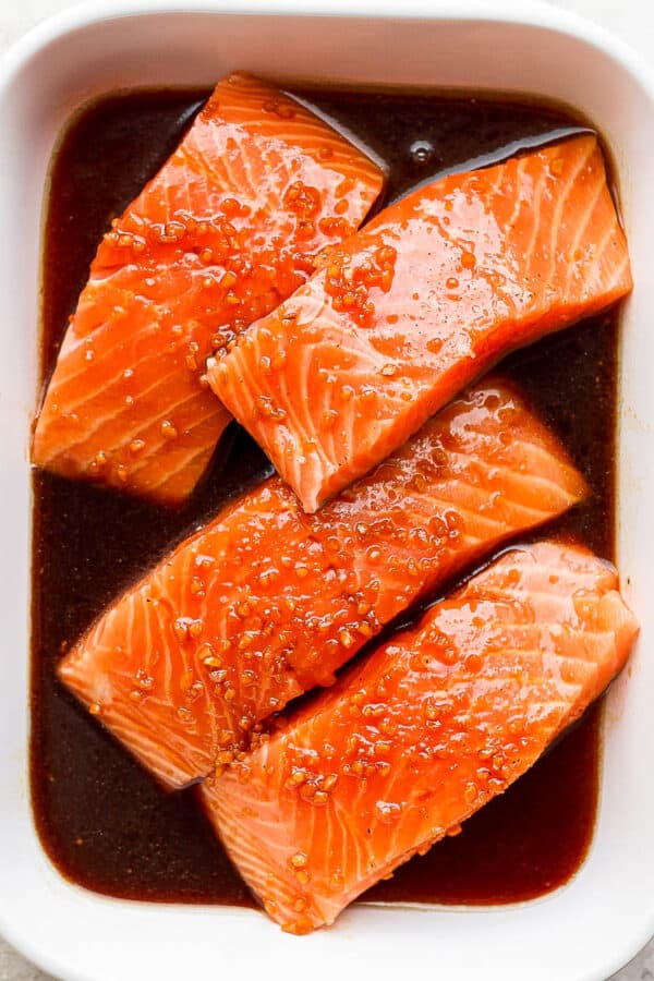 Baking dish with raw salmon and salmon marinade.