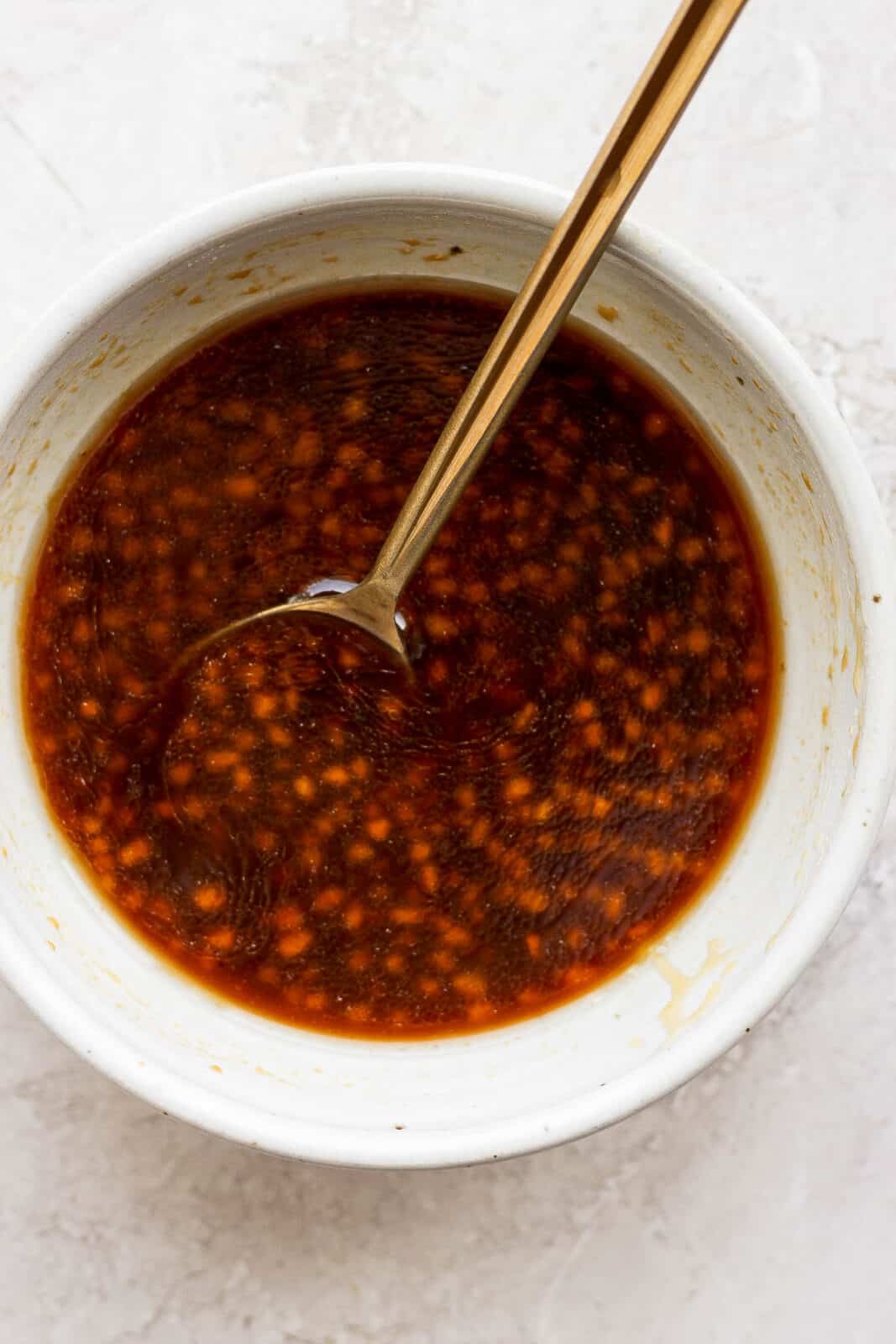 Salmon marinade in a bowl with a spoon.