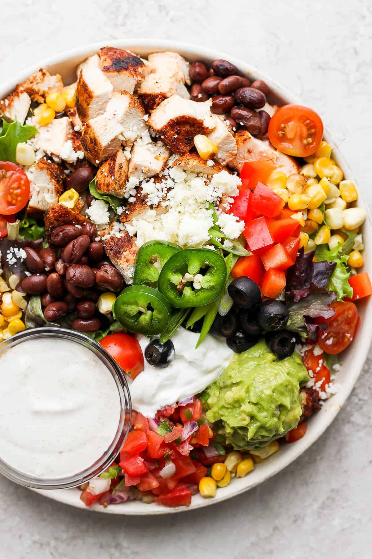 A Santa Fe Salad in a bowl with a small dish of dressing.