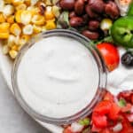 A bowl of southwest dressing sitting inside a santa fe salad.