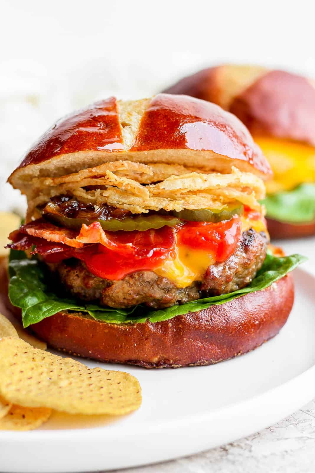 A grilled cheeseburger topped with bacon, ketchup, pickles, onion jam and crispy onion strings. 