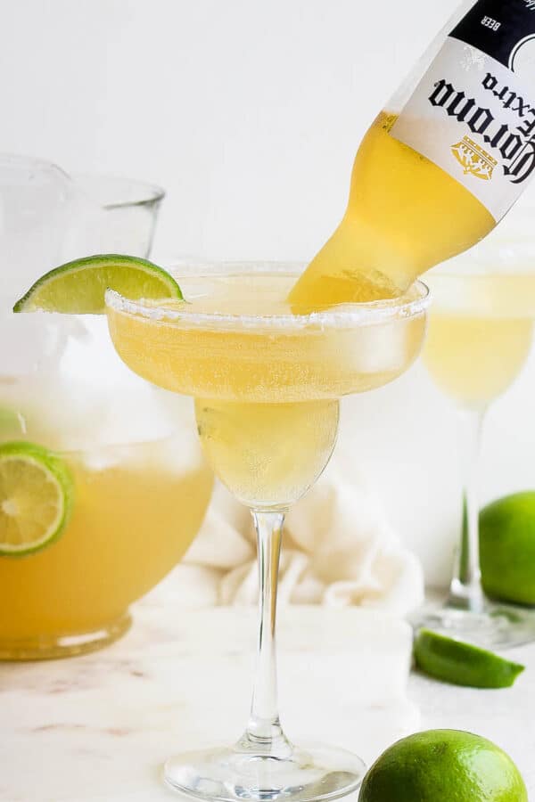 A margarita glass with a beer sticking out of it.