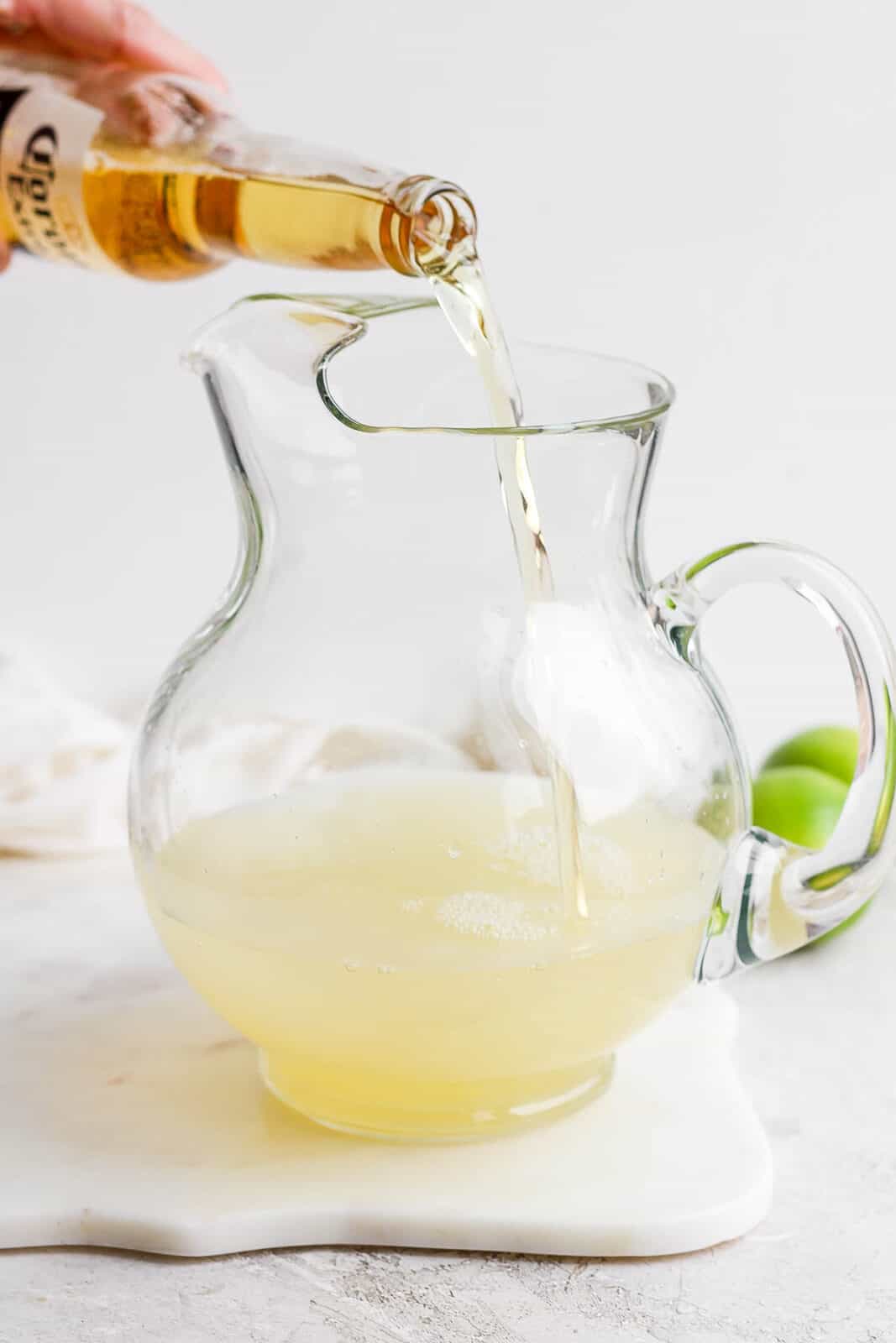 A corona being poured into the pitcher.