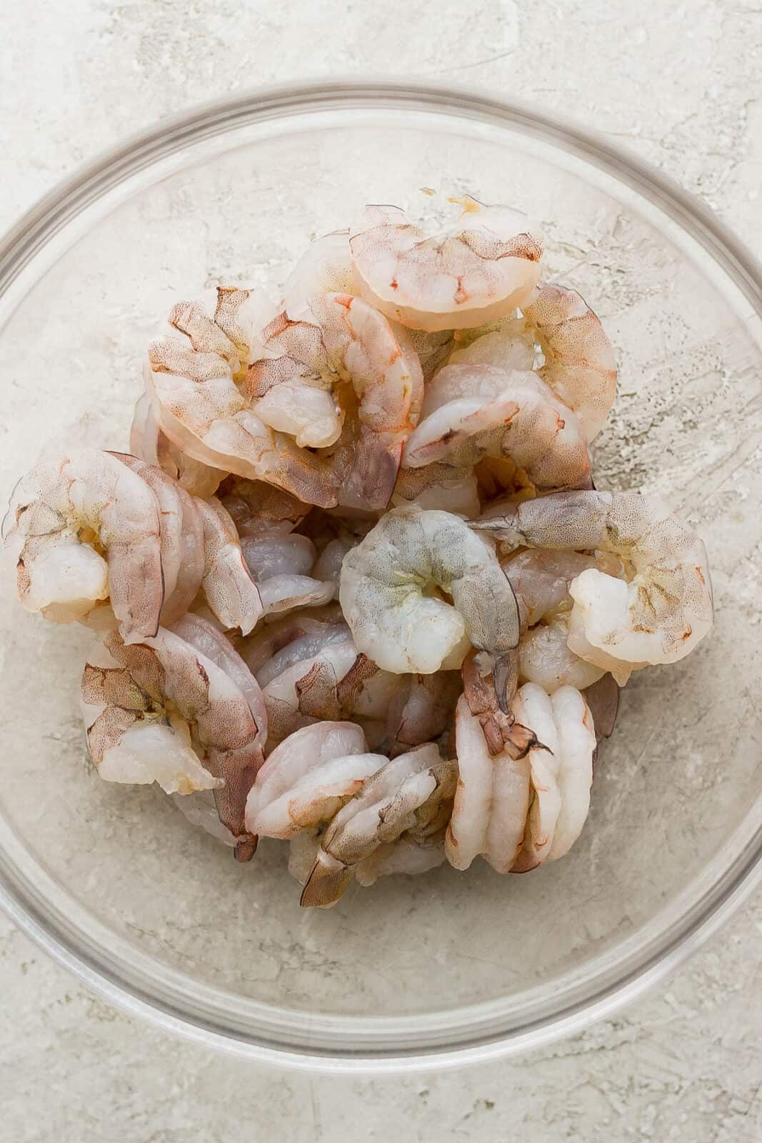 A bowl of thawed shrimp with tails removed.
