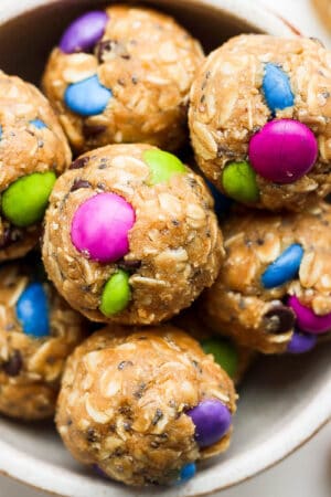 Bowl of no bake energy balls with different colored chocolate candies in them.