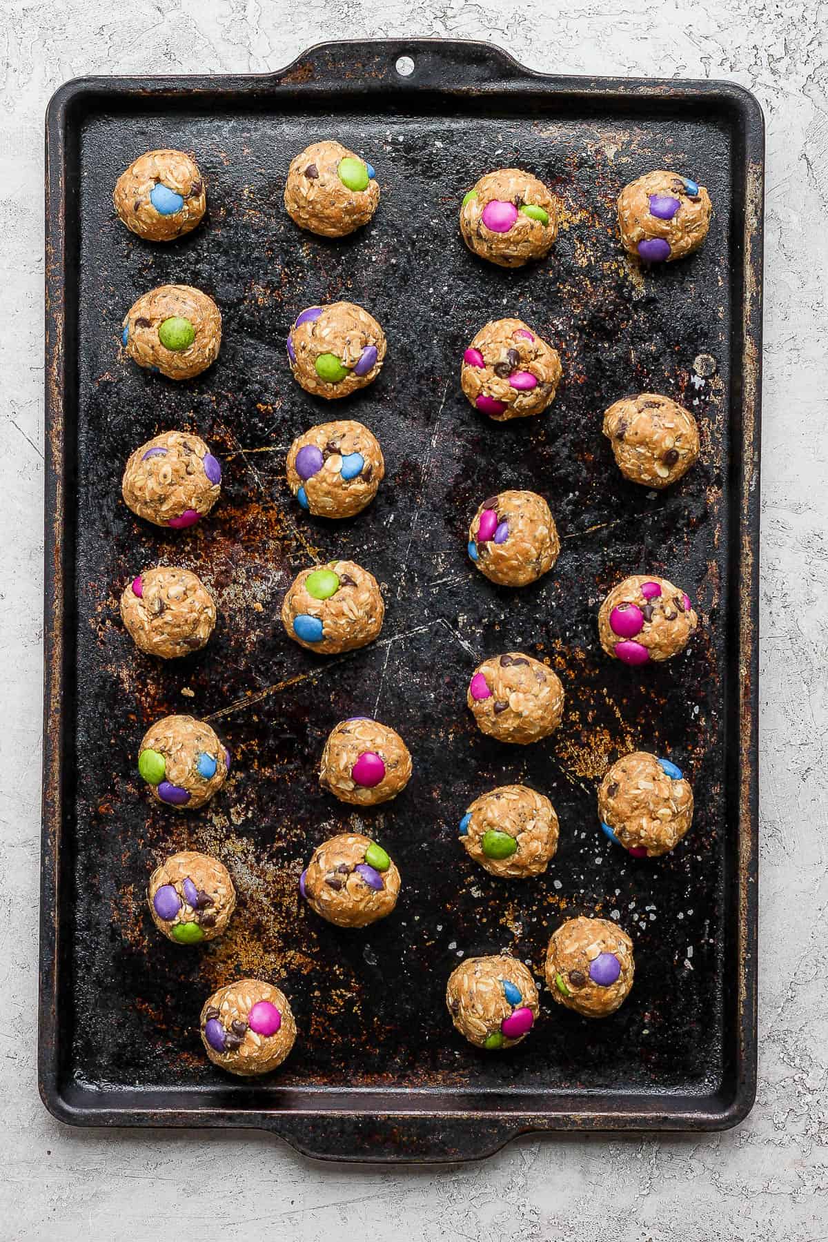 A cookie sheet filled with energy balls about to go in the refrigerator.