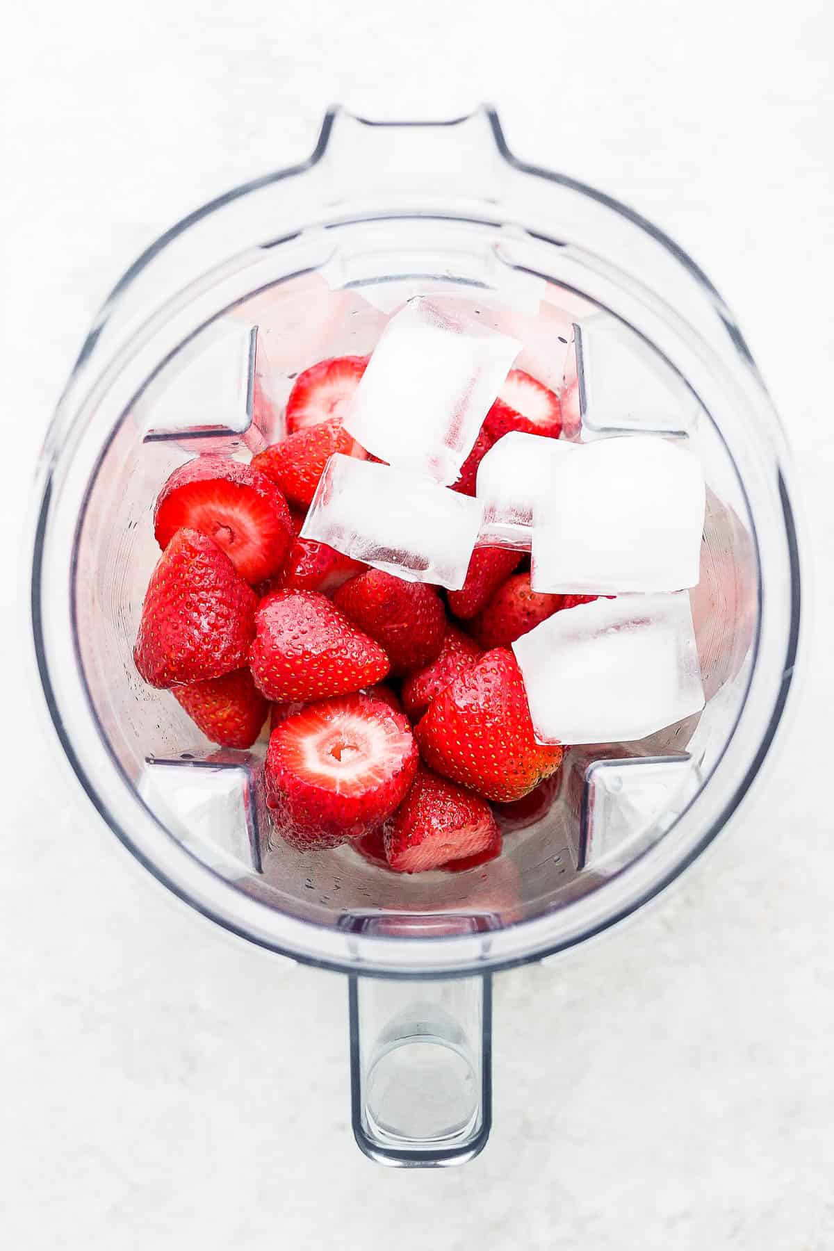 Strawberry margarita ingredients in a blender.