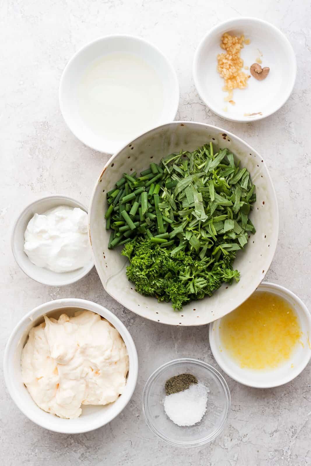 Ingredients for green goddess salad dressing in separate bowls.