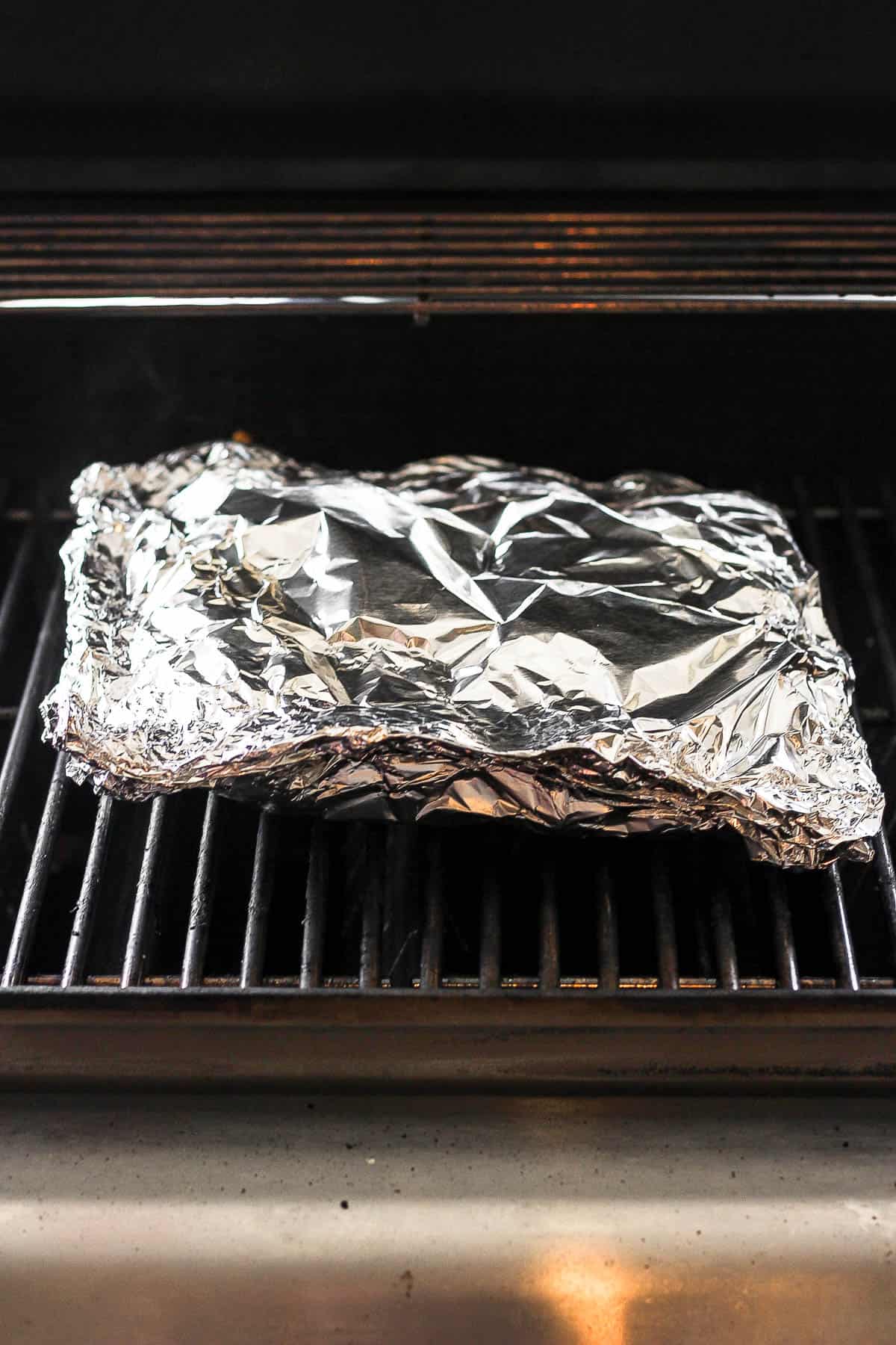 Foil packet with four ears of corn on the grill. 