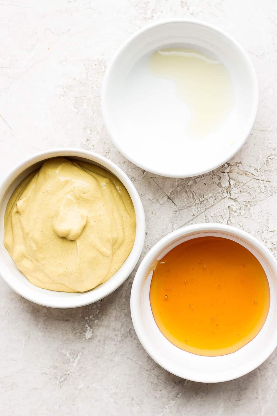 Ingredients for honey mustard in separate bowls.