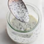 A small jar of poppyseed dressing with a spoon lifting some out.