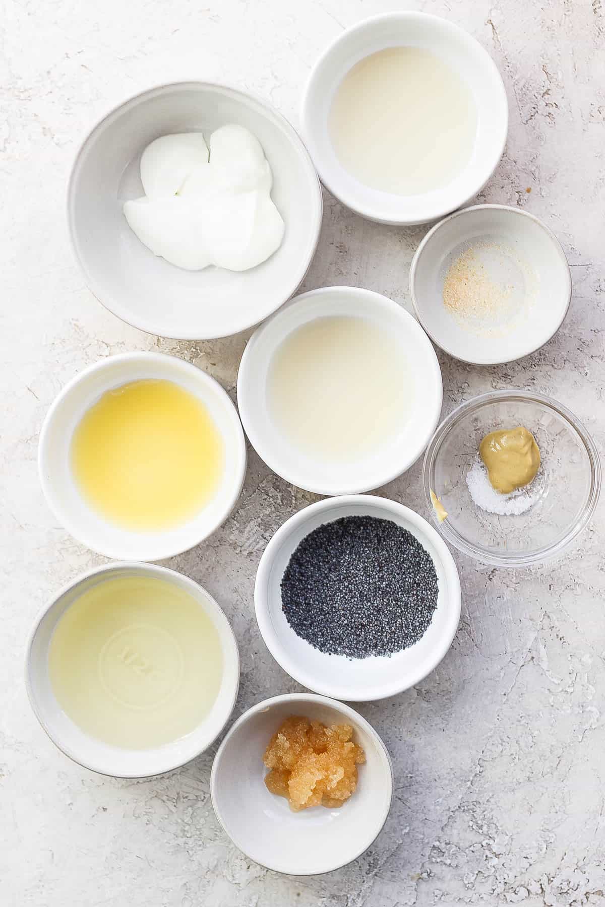 Ingredients for poppyseed salad dressing in separate bowls.