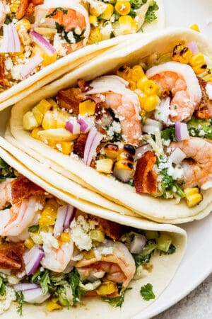 A plate of three shrimp tacos.