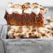 Someone lifting a smores bar out of a 9x9 pan.