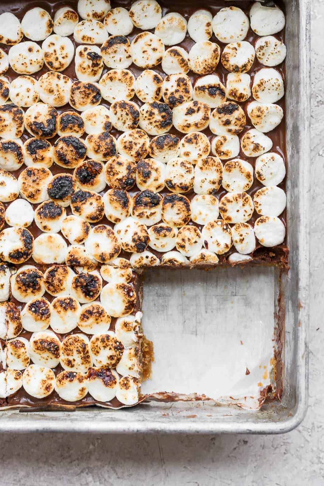 S'mores bars in the baking pan with one bar removed.