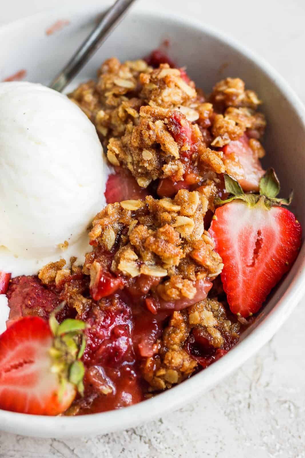 Strawberry crisp and ice cream in a bowl.