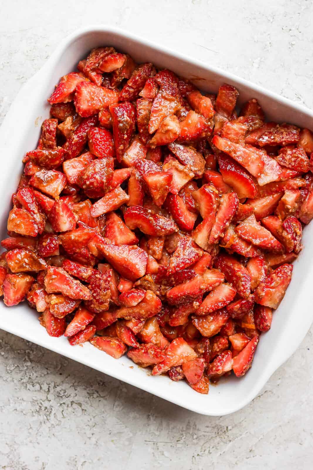 Strawberry filling in a white baking dish.