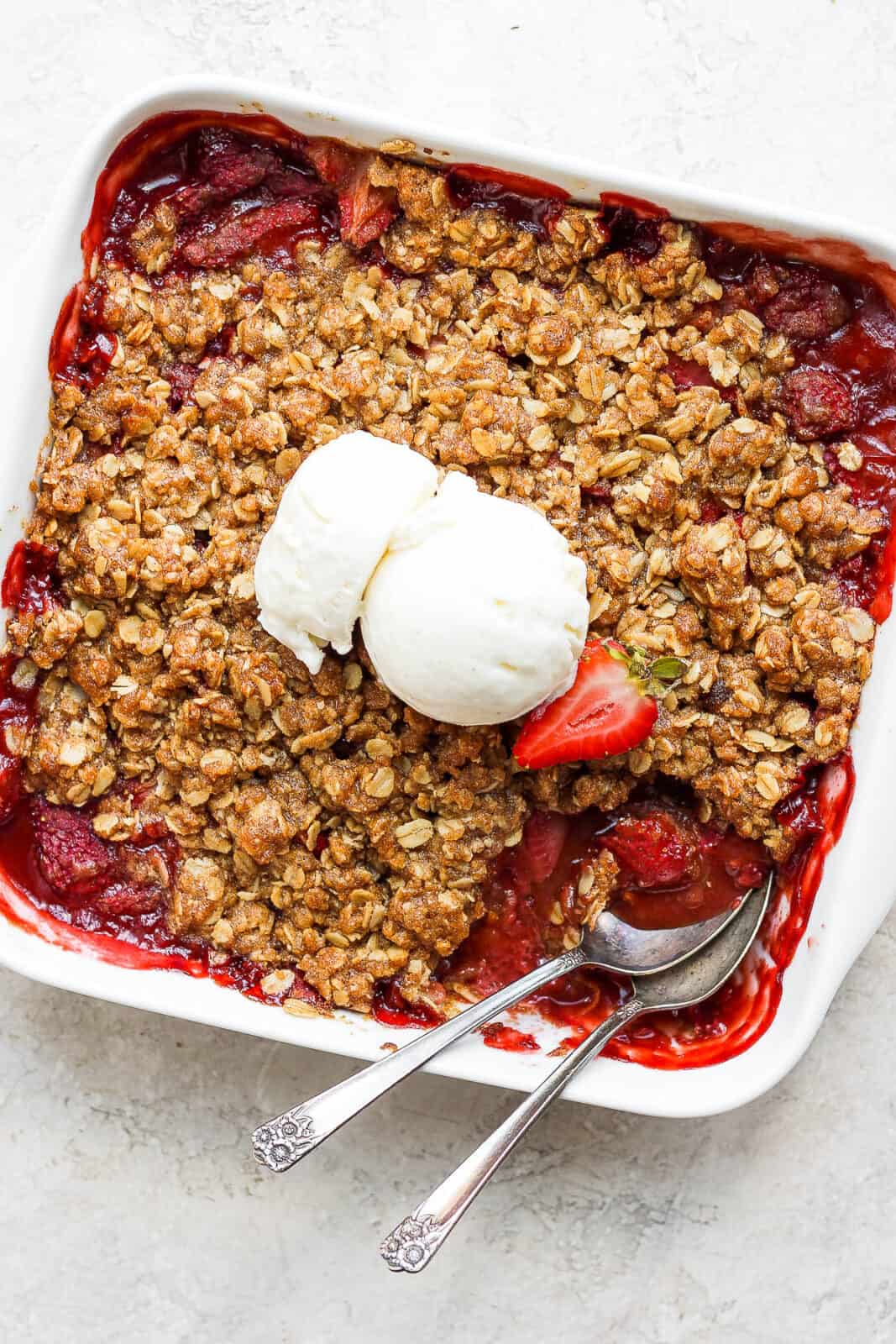 Baked strawberry crisp with vanilla ice cream on top.