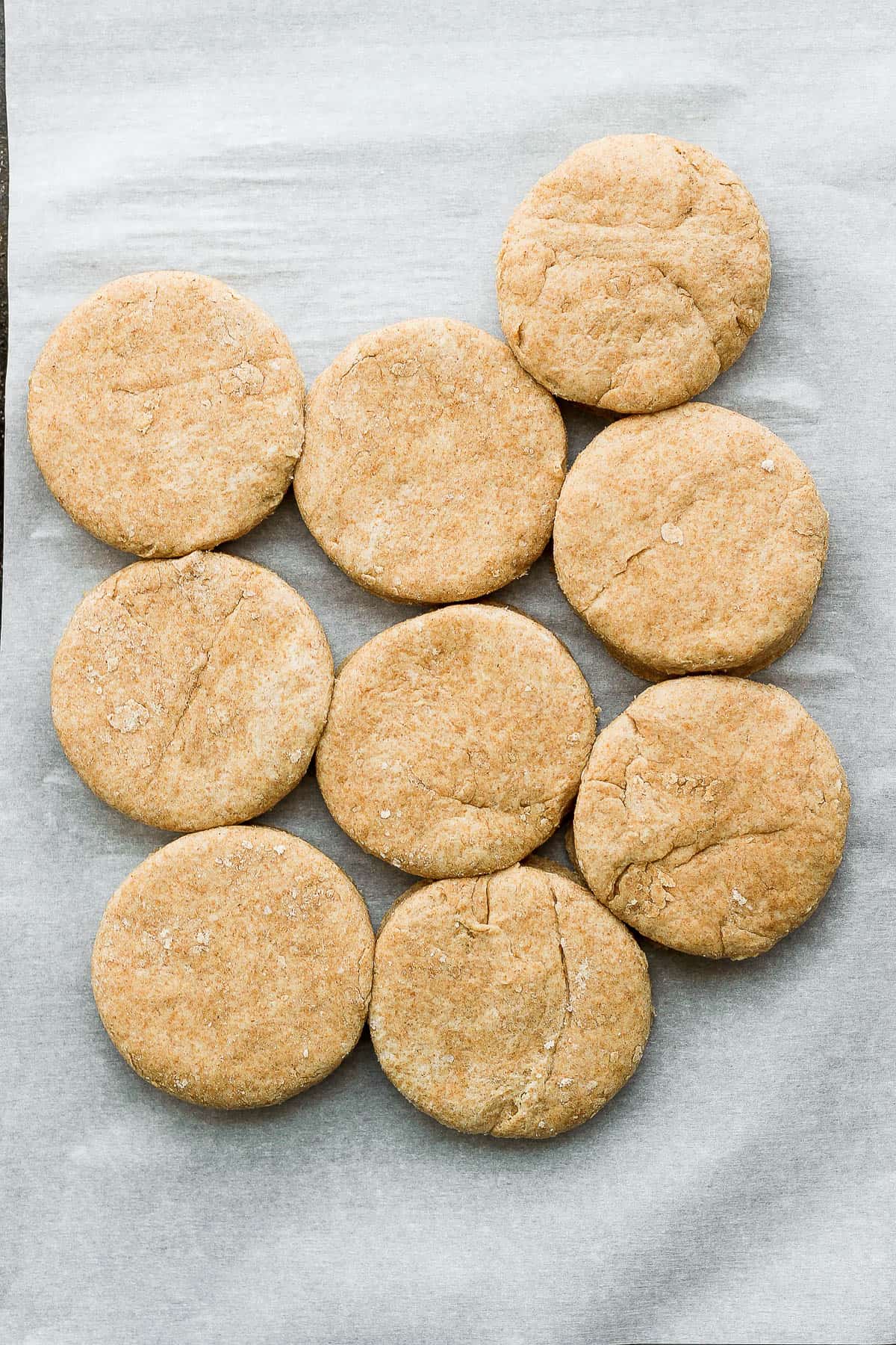 Whole wheat shortcakes on a parchment-lined baking sheet.