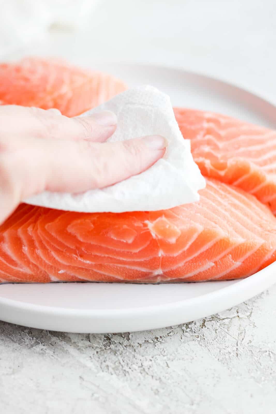 Salmon fillets being pat dry.