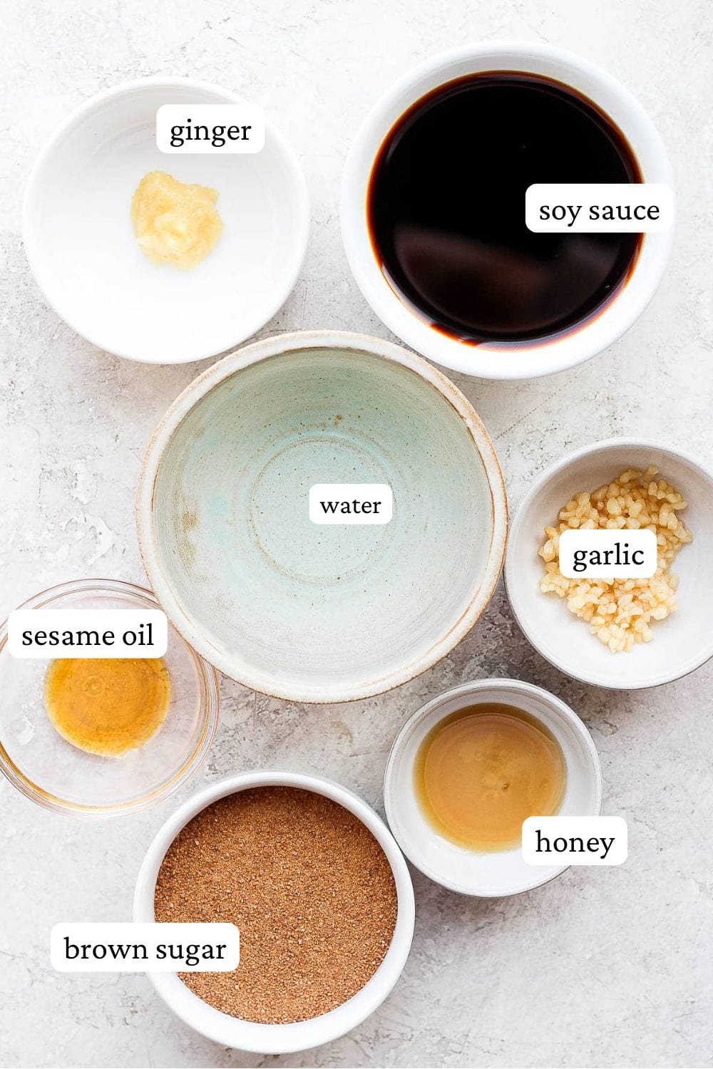 All the ingredients for teriyaki sauce in small bowls and labeled.