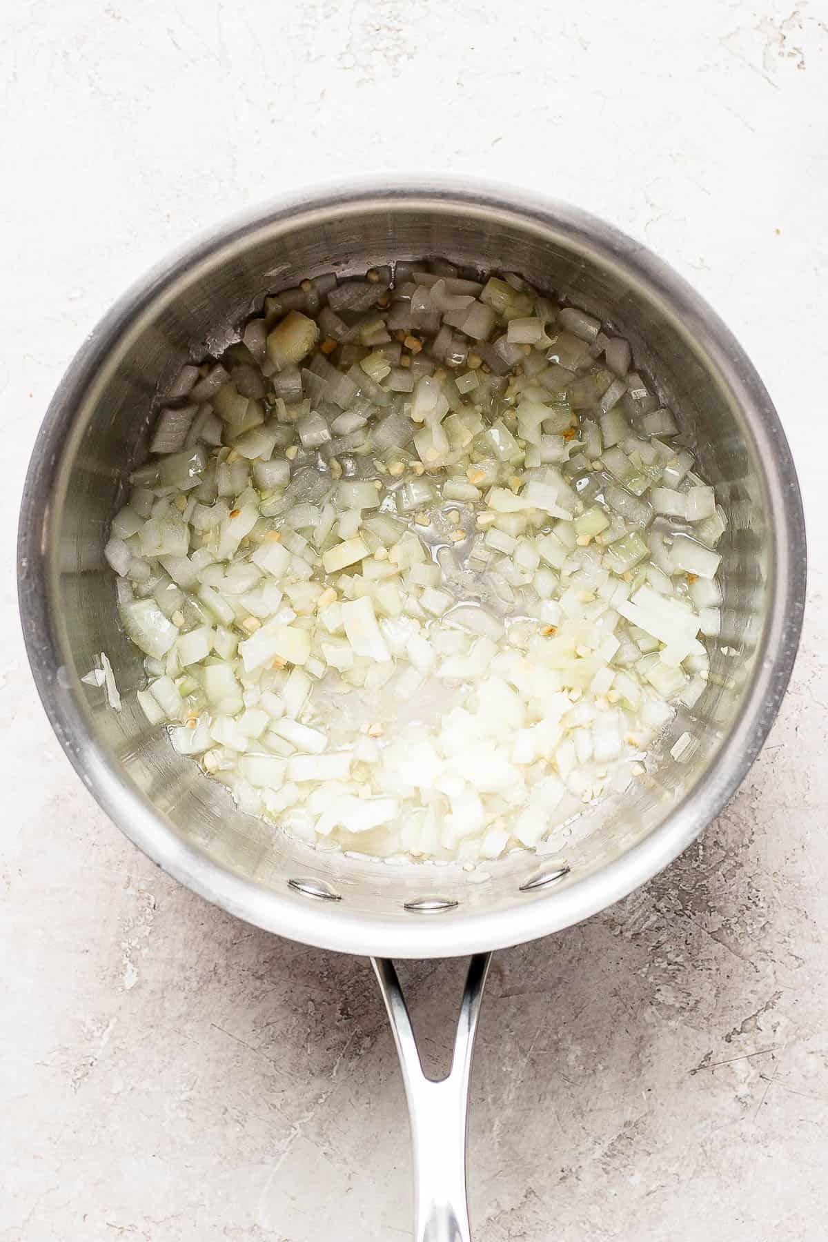 Onion and garlic sautéing in a saucepan.