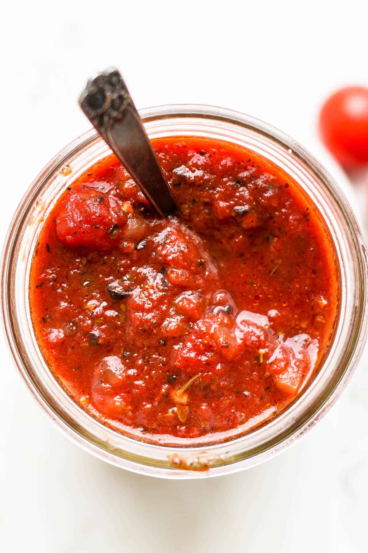 Easy homemade pasta sauce in a mason jar with a spoon.