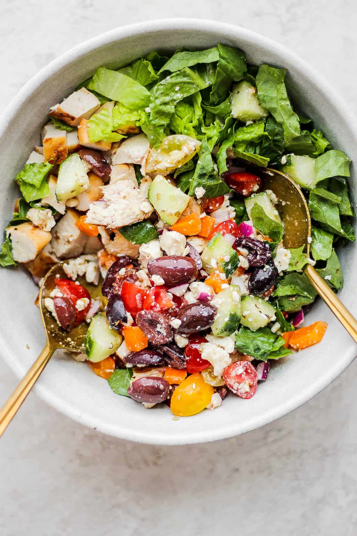 The veggies, romaine lettuce, chicken, and dressing all combined in a bowl.