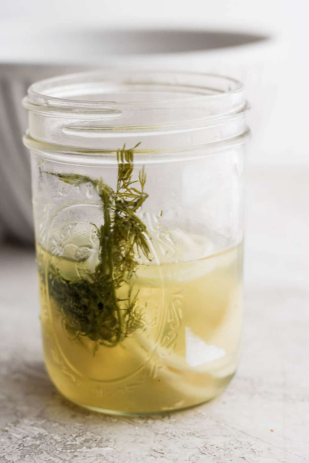 Pickle juice with dill in a mason jar.