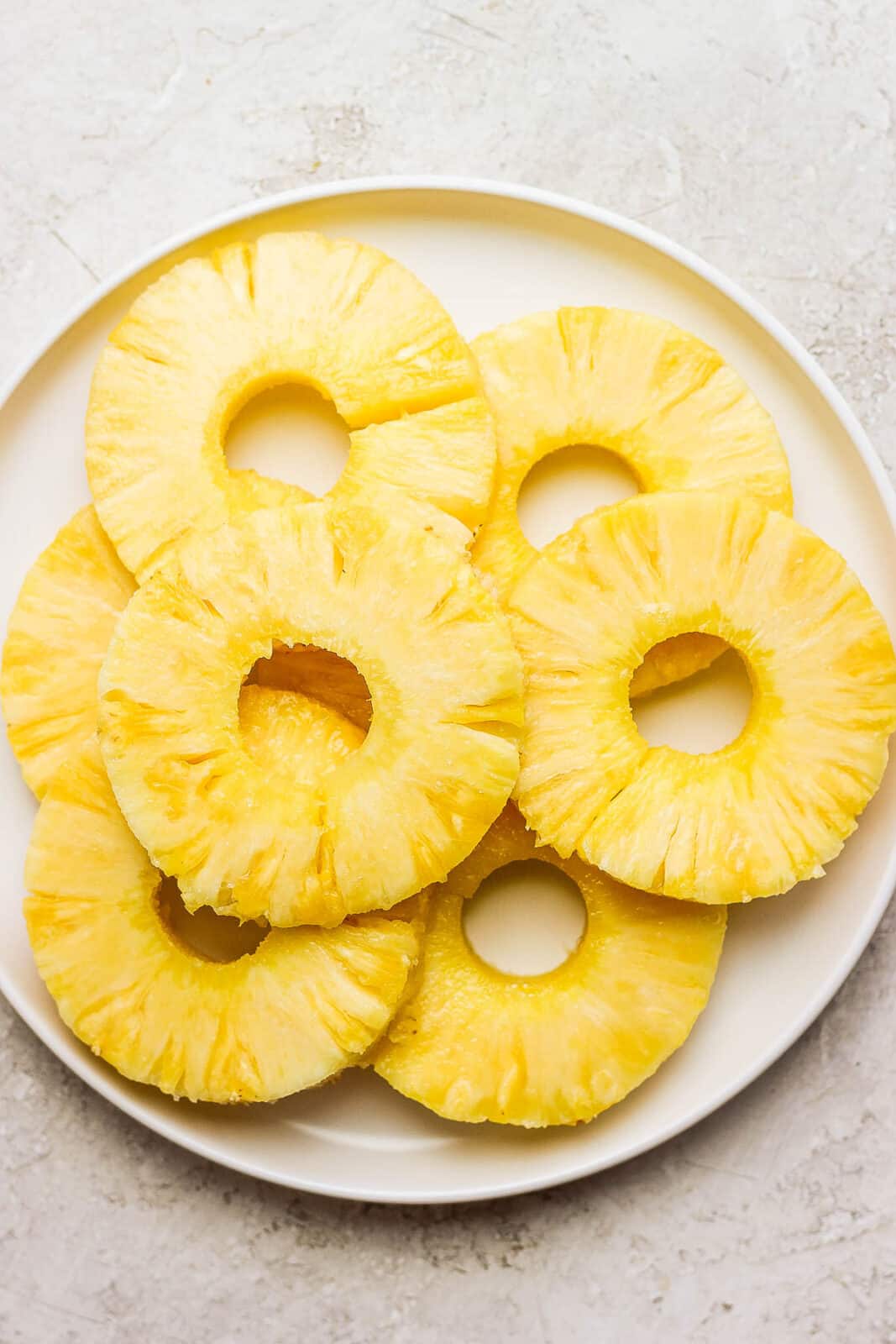 Pineapple slices brushed with olive oil and honey on a plate.