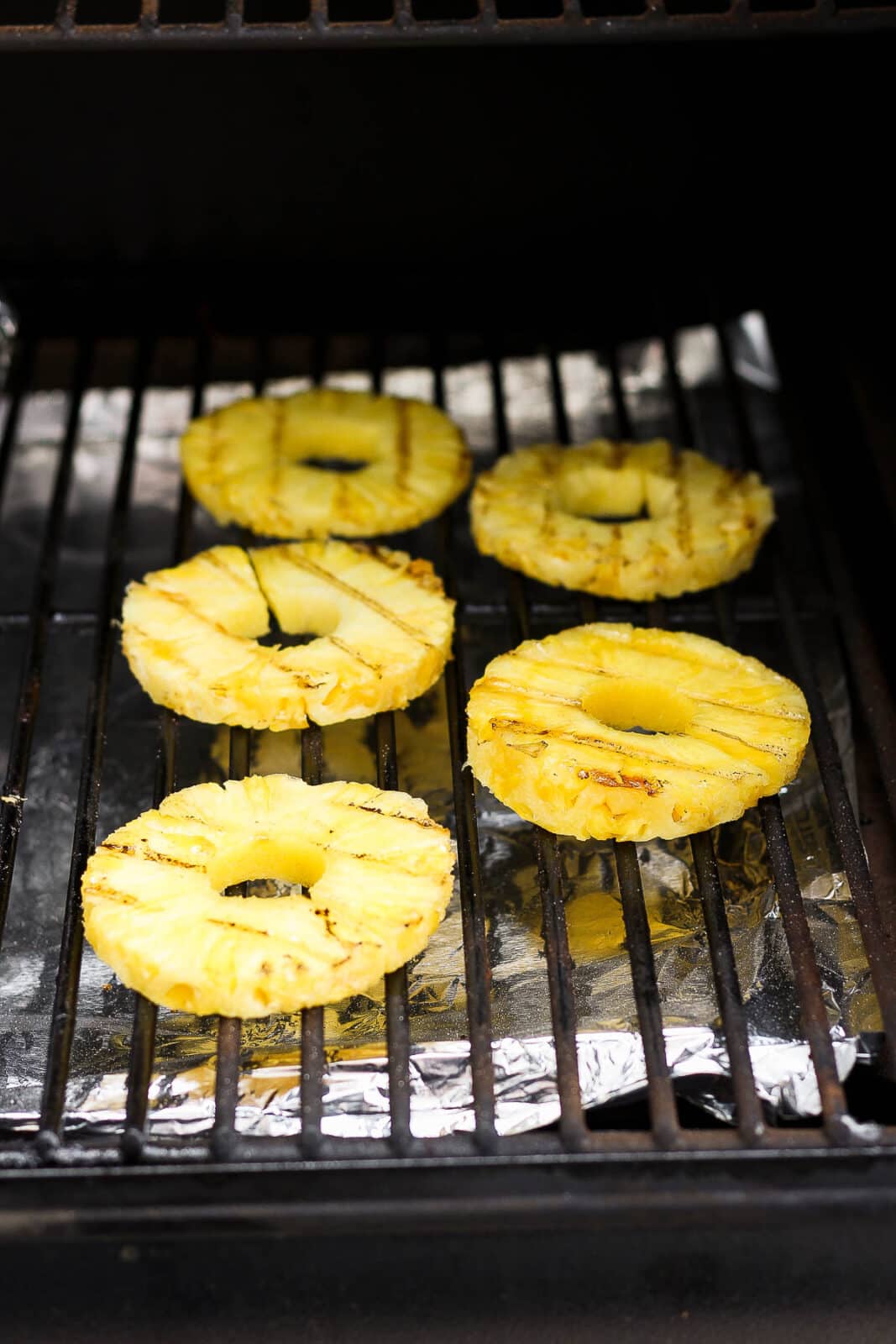 Pineapple slices on the smoker.