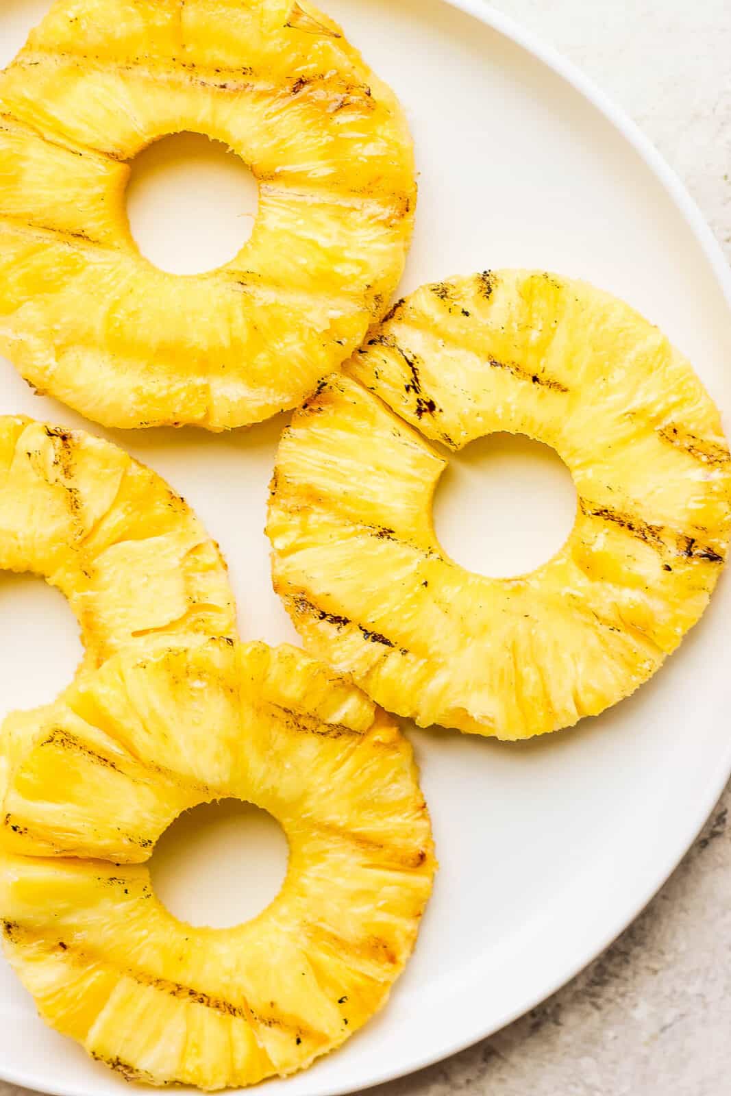 Smoked pineapple slices on a plate.