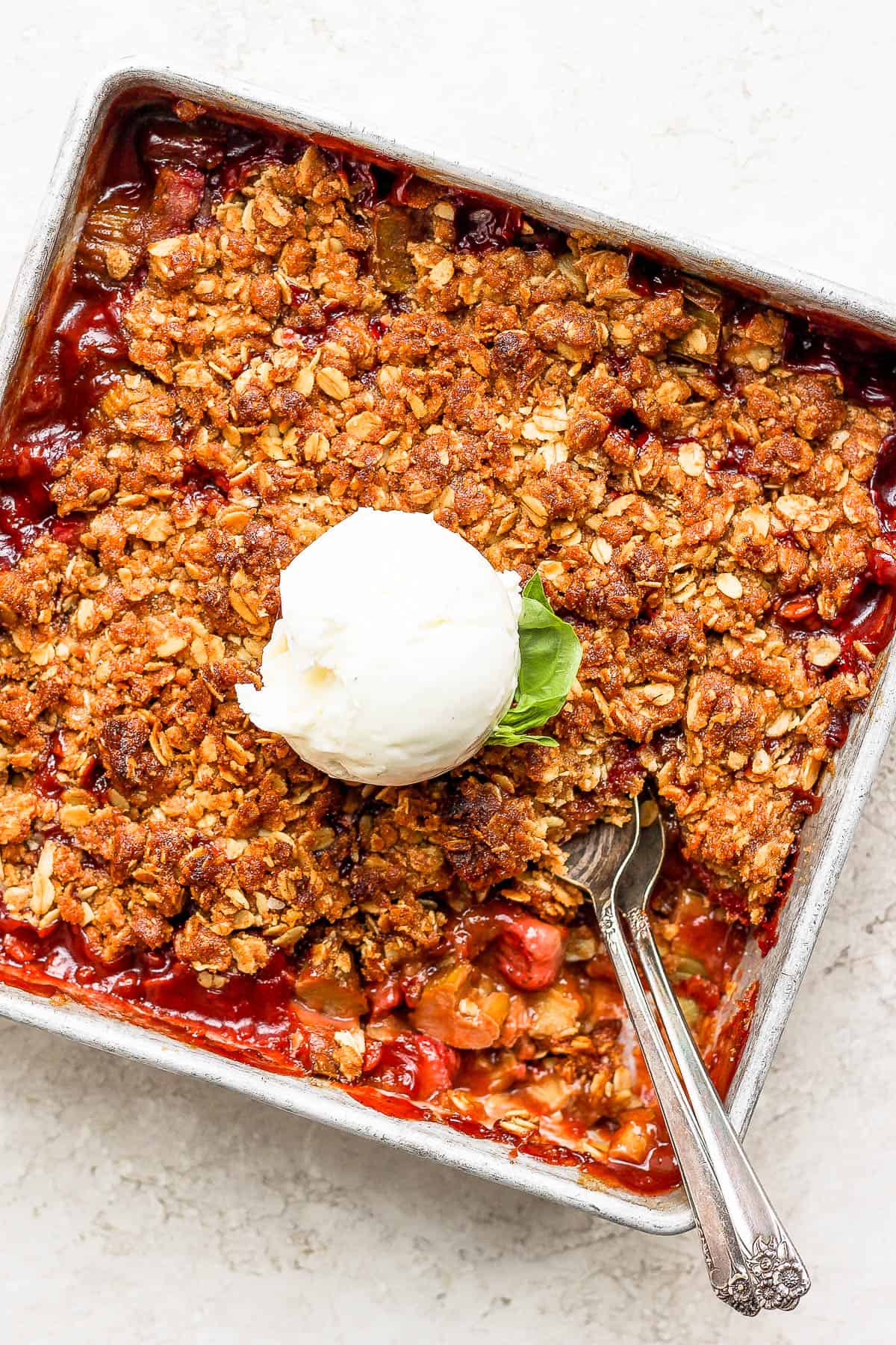 Strawberry rhubarb crisp topped with a scoop of vanilla ice cream. 