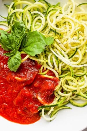 A bowl of zucchini spaghetti with fresh basil garnish.