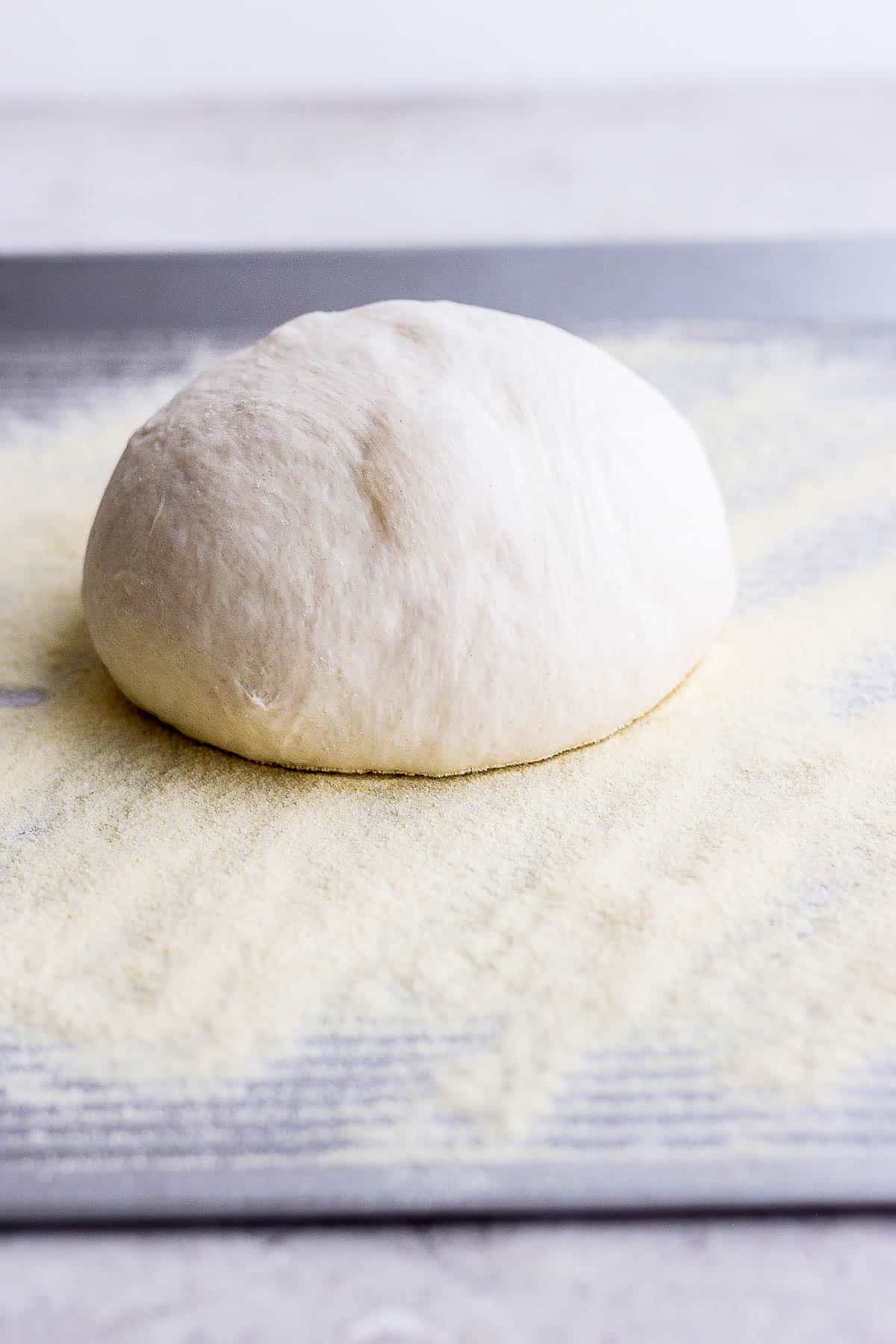 Pizza dough on semolina flour, ready to be rolled out.