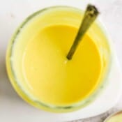Top shot of a mason jar of honey mustard dressing with spoon sticking out.