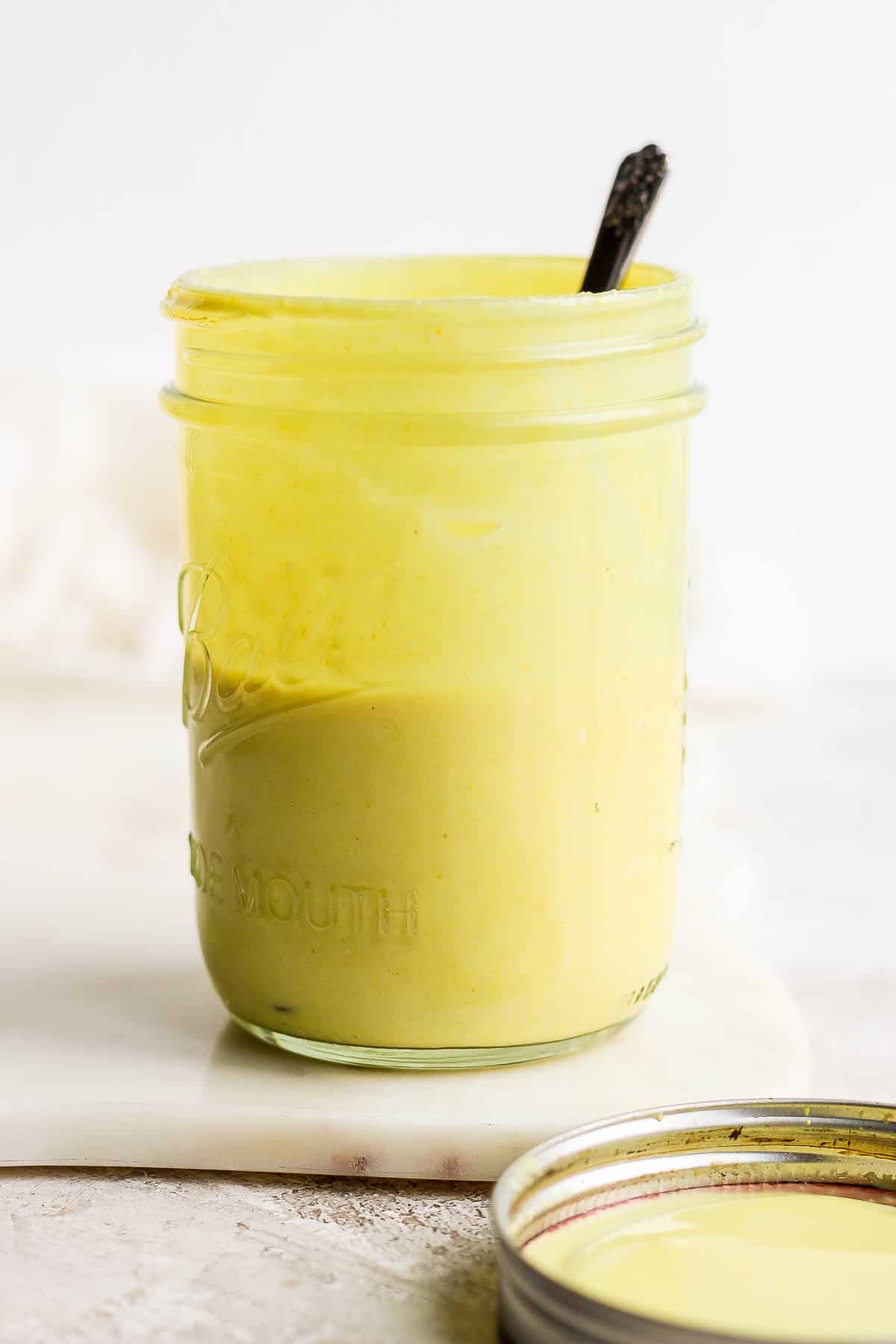 Honey mustard salad dressing with a spoon.