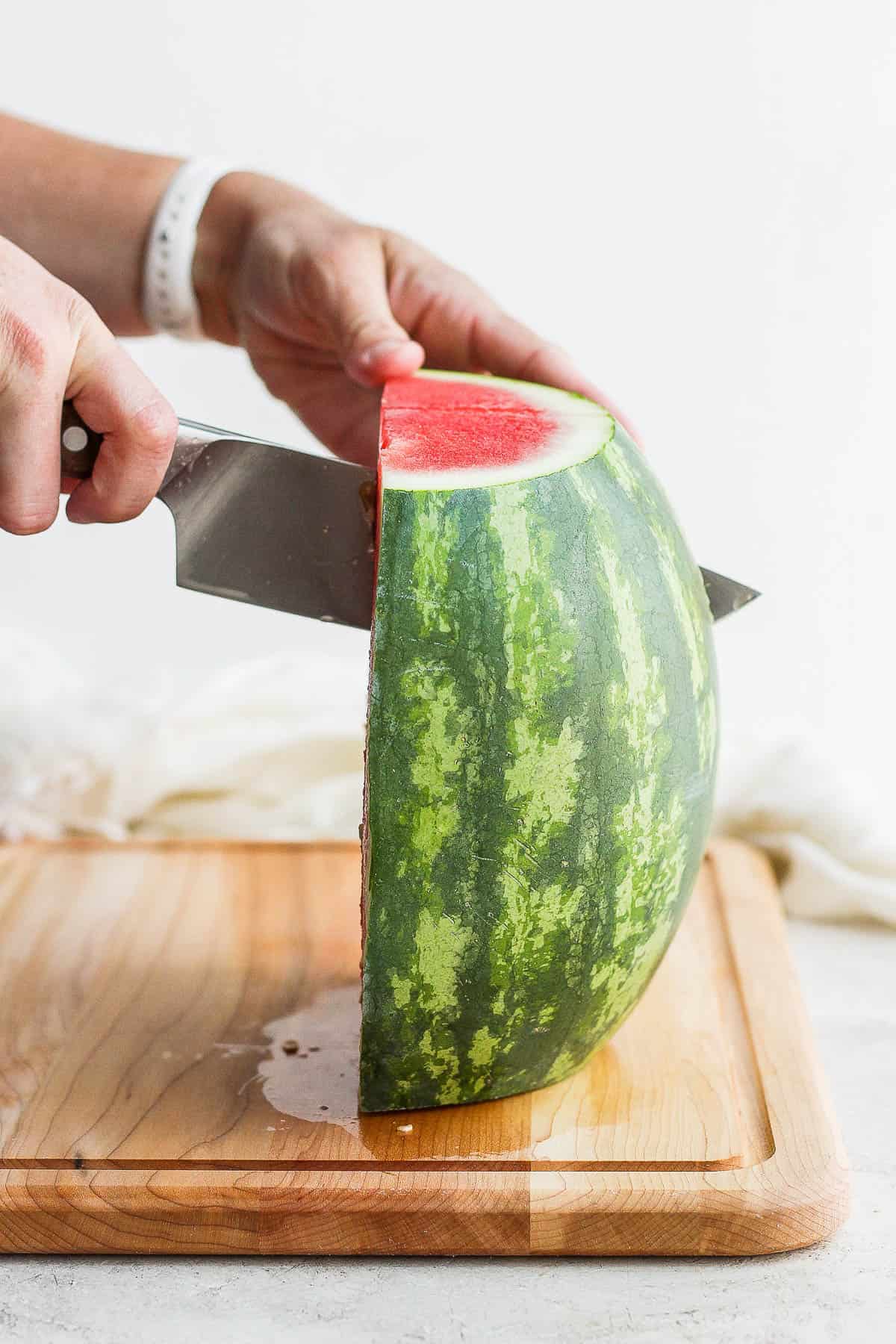 Half of a watermelon being cut into quarters.