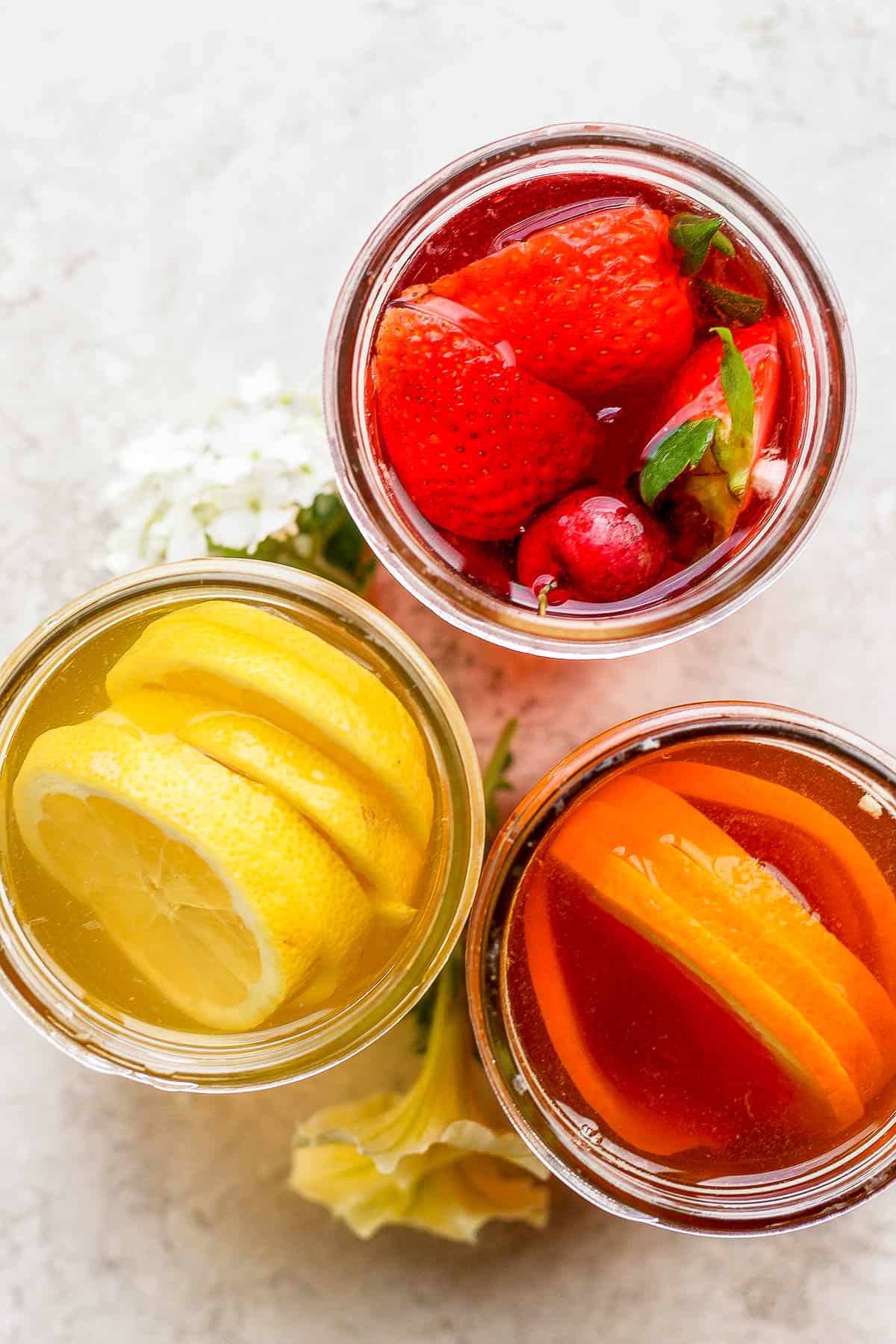 Fruit in cold brew iced tea in mason jars.