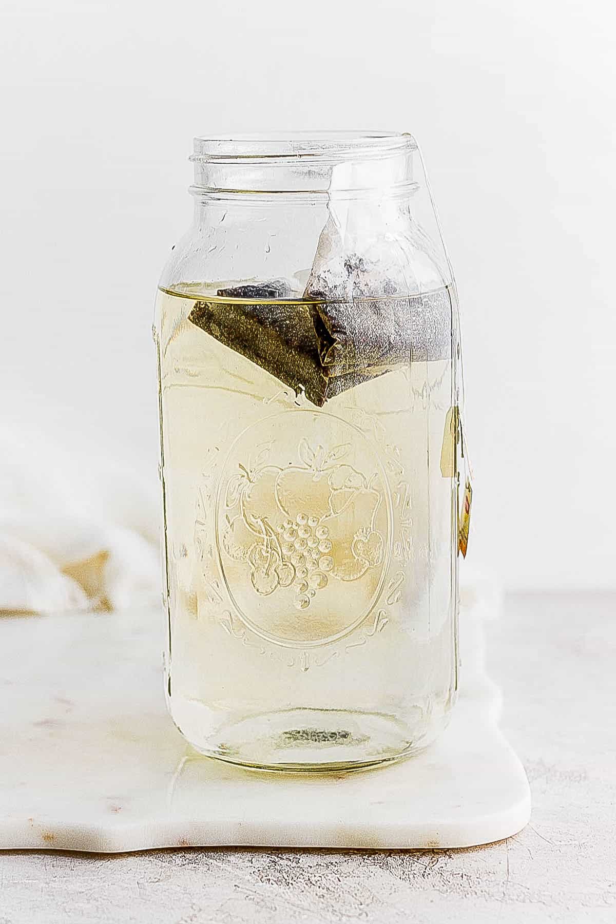 Tea bags placed in water in a glass container.