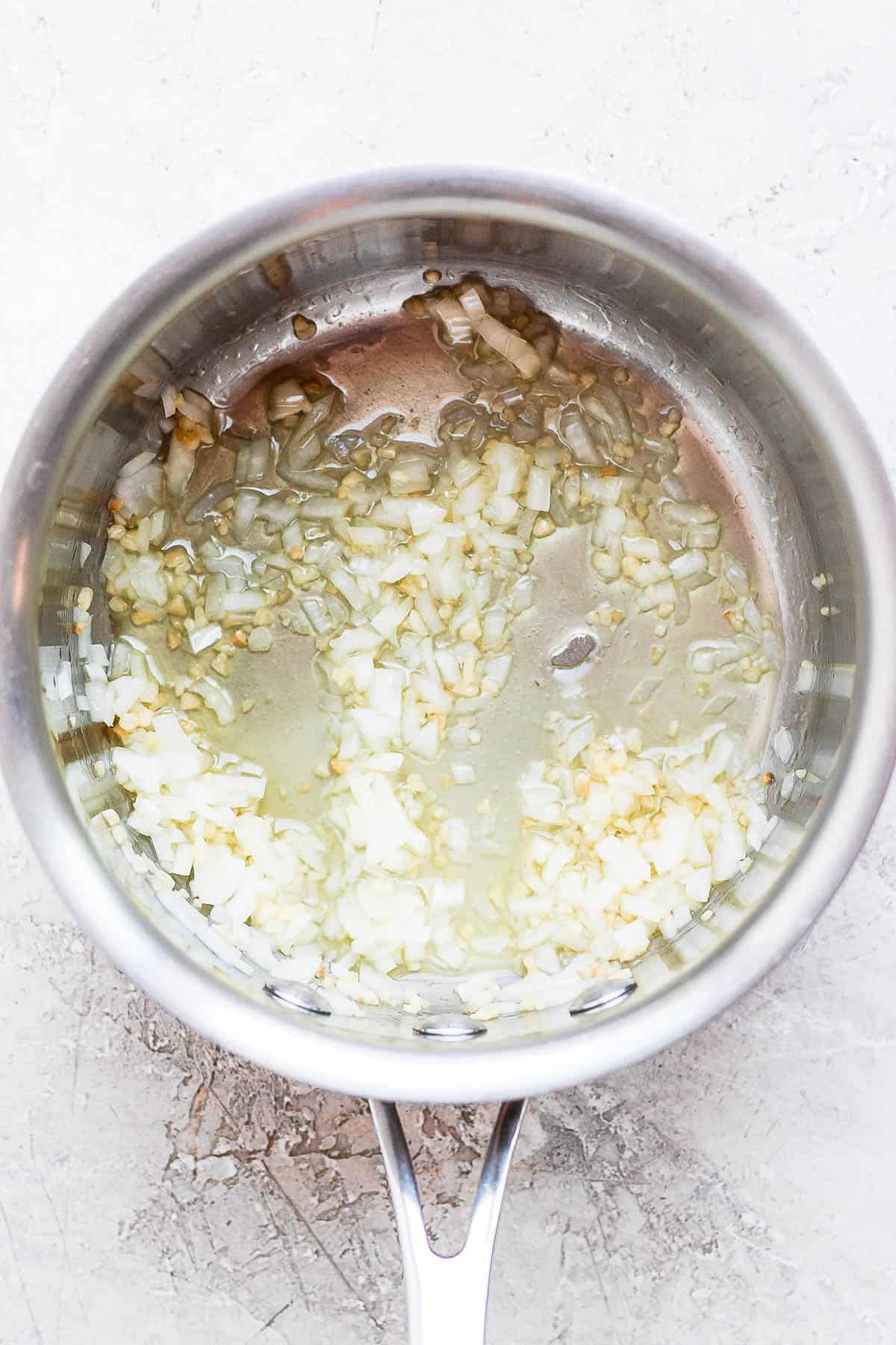 Onion and garlic sautéing in a pan.