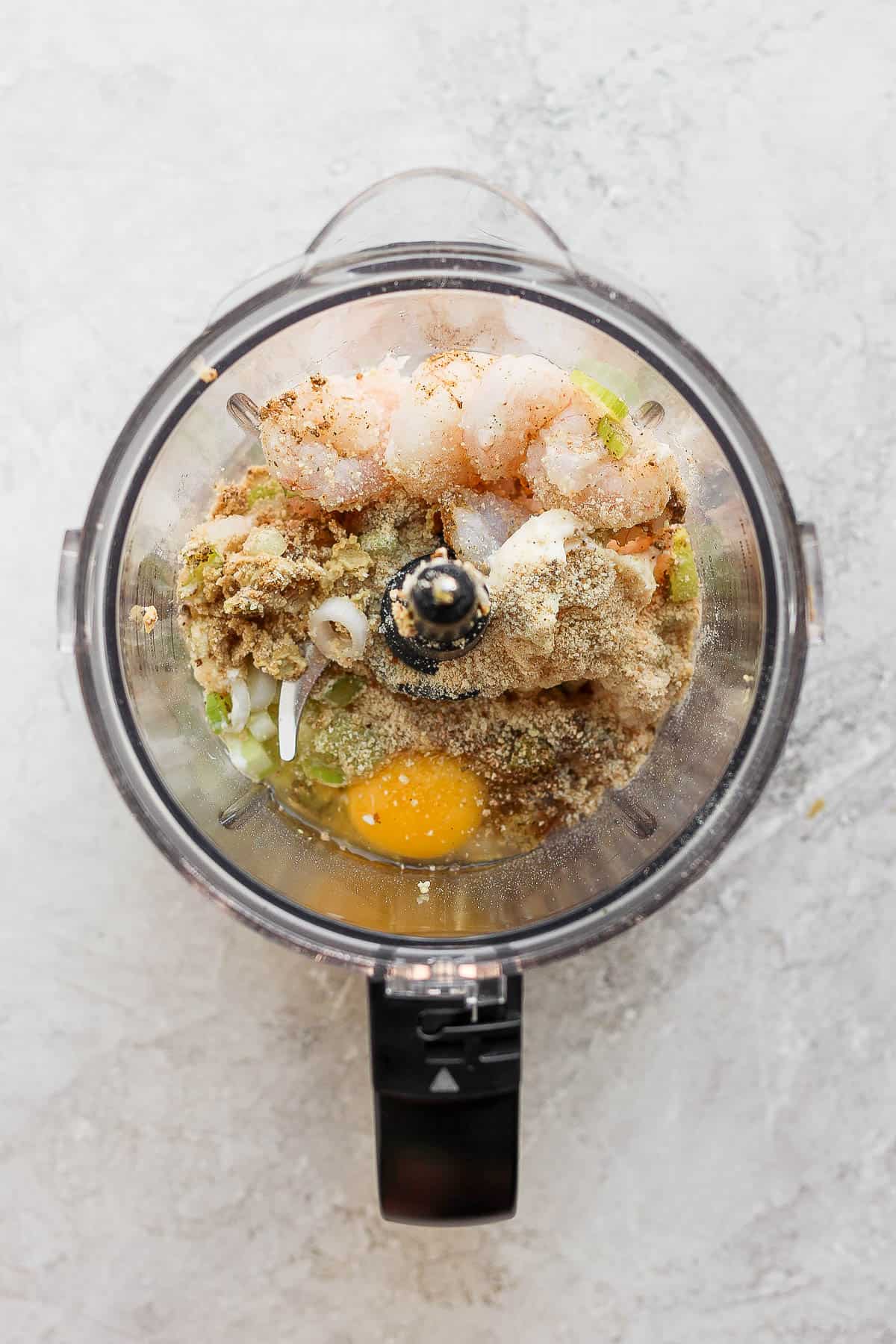 Ingredients for shrimp burgers in a food processor.