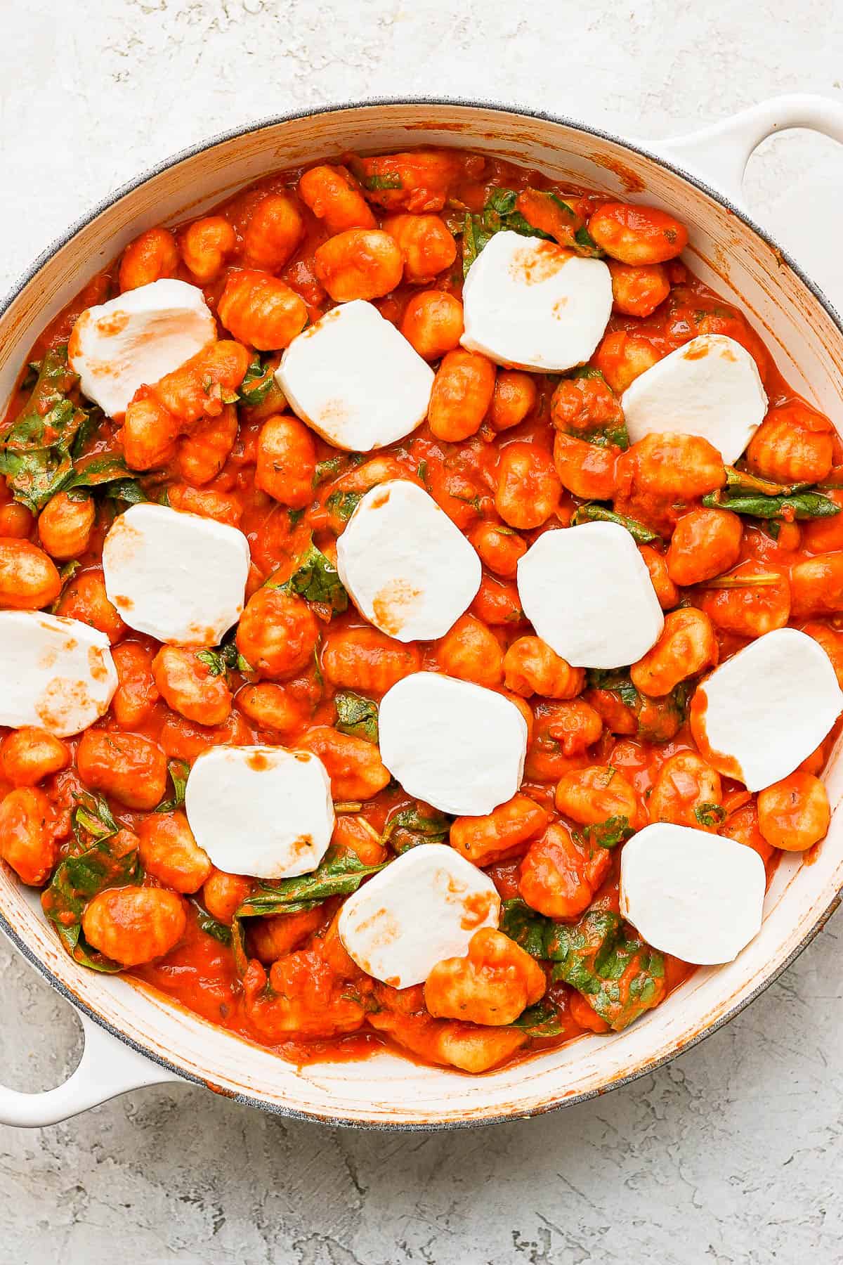 Mozzarella slices added on top of the gnocchi.