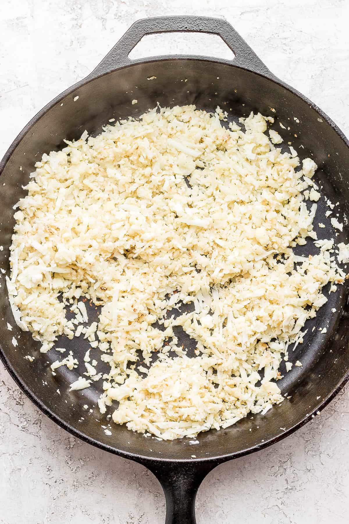 Cauliflower rice in a cast iron skillet.