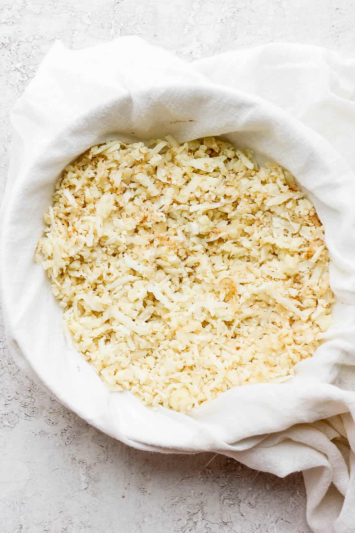 Cooked cauliflower rice in a cheesecloth.