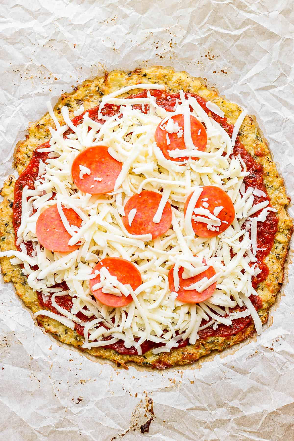 Sauce, cheese, and pepperoni added to a cauliflower pizza crust.