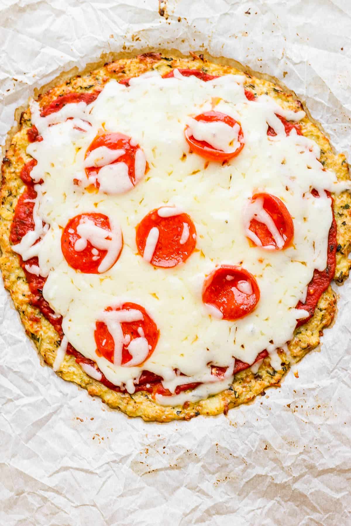 A baked pizza on a cauliflower pizza crust.