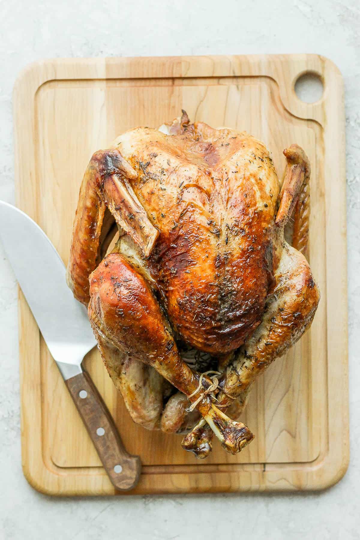 A fully cooked turkey resting on a cutting board.
