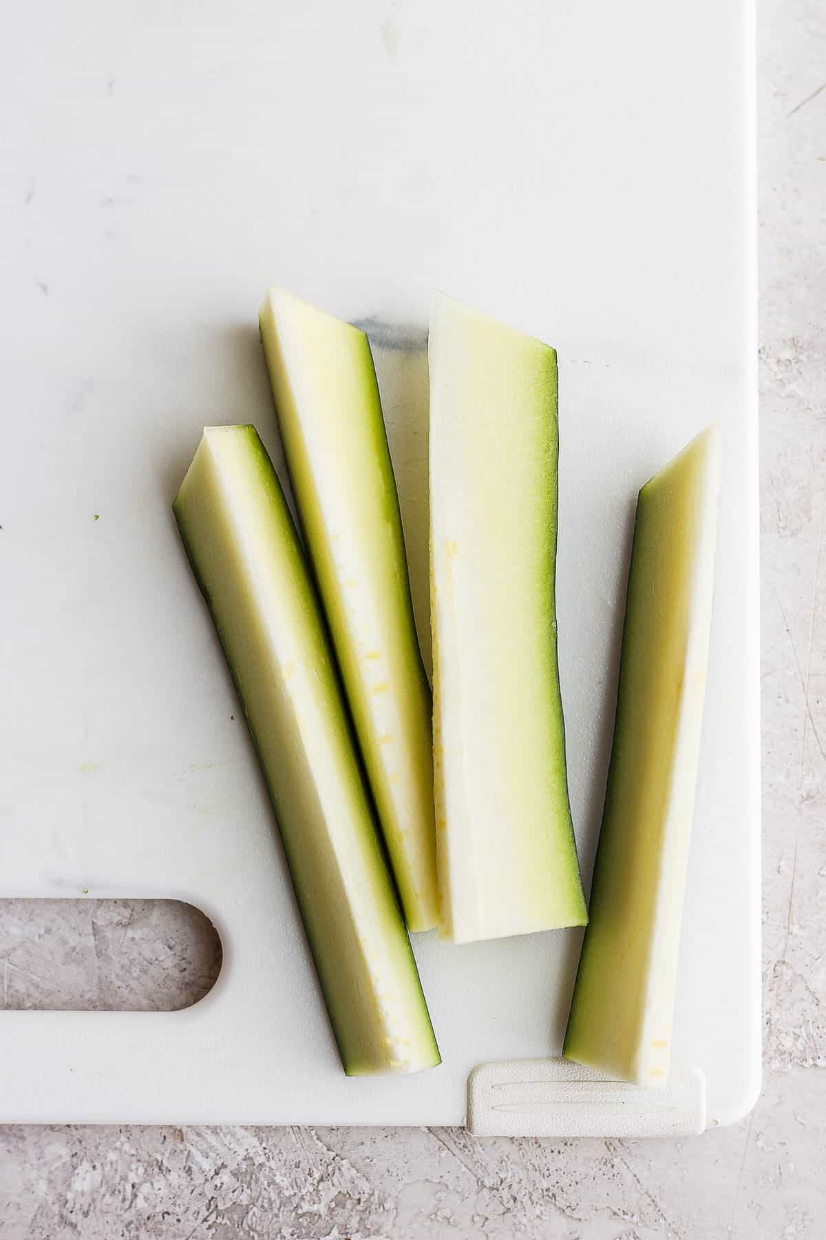 Zucchini sticks on a cutting board.